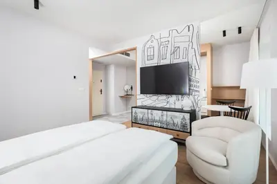 a white room with a bed and a chair at City of the Kings-Riverside K22M16 in Kraków