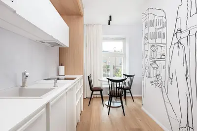 a kitchen with a table and chairs and a drawing on the wall at City of the Kings-Riverside K22M16 in Kraków