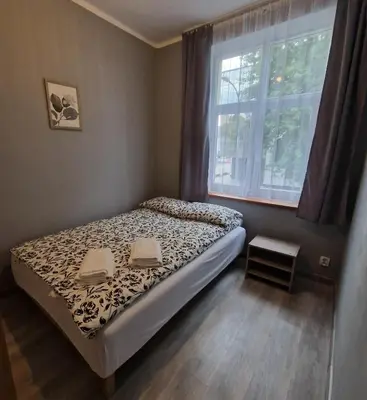 a small bedroom with a bed and a window at Apartament Anna in Kraków