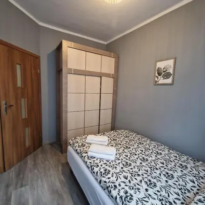a small bedroom with a bed and a wooden door at Apartament Anna in Kraków