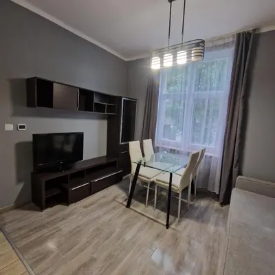 a living room with a glass table and a television at Apartament Anna in Kraków