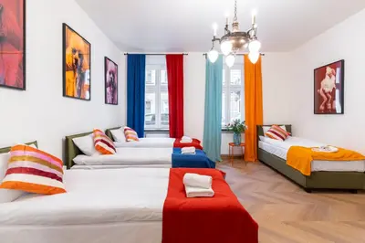 a room with four beds and a chandelier at Horizon Apartments - Zamenhofa in Kraków