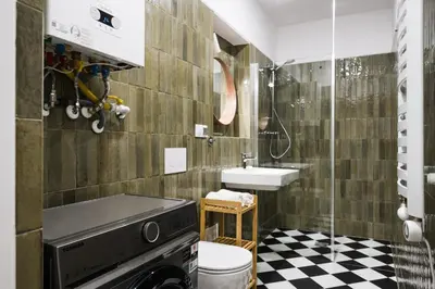 a bathroom with a sink and a washing machine at Horizon Apartments - Zamenhofa in Kraków