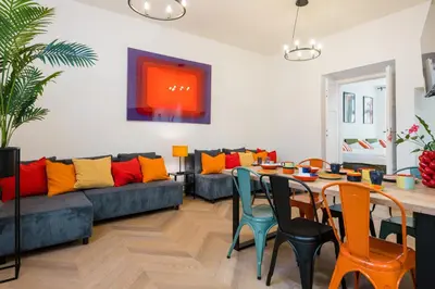 a living room with a couch and a table and chairs at Horizon Apartments - Zamenhofa in Kraków