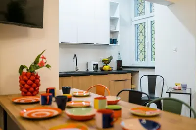 a kitchen with a wooden table with plates on it at Horizon Apartments - Zamenhofa in Kraków