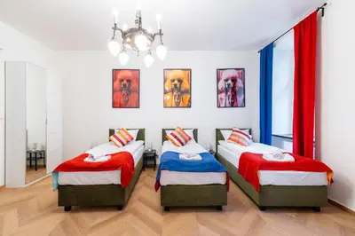 a bedroom with two twin beds and a chandelier at Horizon Apartments - Zamenhofa in Kraków