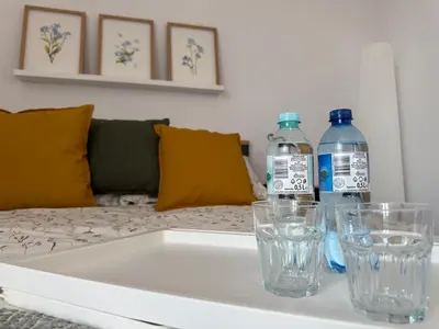 two water bottles and glasses sitting on a table at Apartament Żabie Oczko in Zator