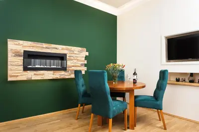 a dining room with a table and chairs and a fireplace at Apartament Vinci in Kraków