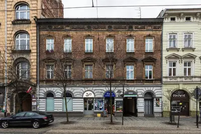 a large brick building with a car parked in front of it at Apartament Vinci in Kraków