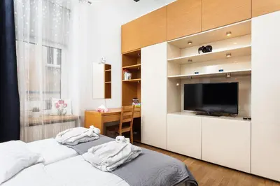a bedroom with two beds and a flat screen tv at Apartament Vinci in Kraków