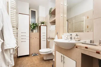 a bathroom with a white sink and a toilet at Apartament Vinci in Kraków