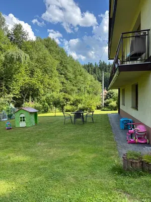a yard with a table and chairs and a house at Nad potokiem in Nowy Targ