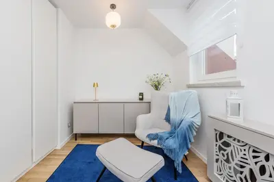 two pictures of a bathroom with a toilet and a television at Apartament przy Wiśle in Kraków