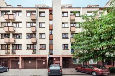 a large building with cars parked in front of it at Apartament przy Wiśle in Kraków