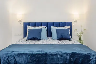 a blue bed with blue sheets and pillows at Apartament przy Wiśle in Kraków