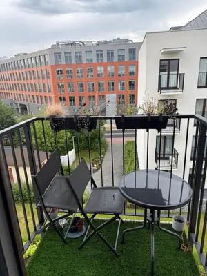 a balcony with a table and two chairs and a table at Zablocie Apartment near to Schindler Fabric - 48m2 in Kraków
