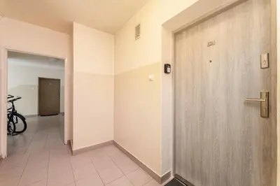 a hallway with a wooden door and a tile floor at Grzegórzki Chic Studio by BookingHost in Kraków