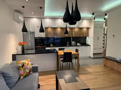 a kitchen and living room with a couch and a table at Lubicz Apartment 70m2 in Kraków