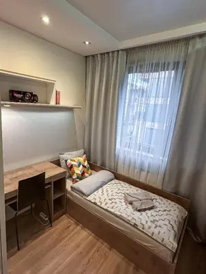 a room with a bed and a desk and a window at Lubicz Apartment 70m2 in Kraków