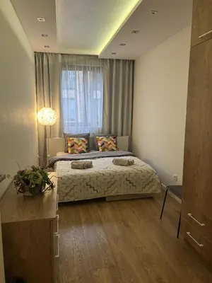 a bedroom with a large bed and a window at Lubicz Apartment 70m2 in Kraków