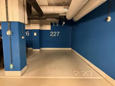 a room with a blue wall and a concrete floor at Lubicz Apartment 70m2 in Kraków