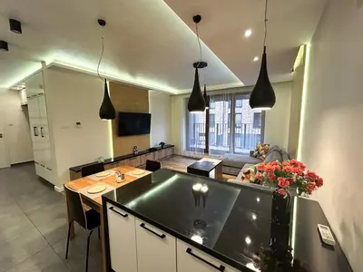 a kitchen and living room with a table and a couch at Lubicz Apartment 70m2 in Kraków