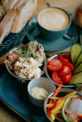 a plate of food with vegetables and a cup of coffee at LORETO 2 by Cozyplace in Kraków