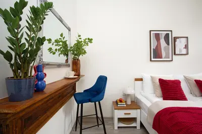 a bedroom with a bed and a blue chair at LORETO 2 by Cozyplace in Kraków