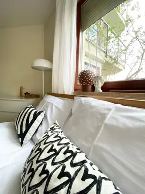 a white bed with a pillow and a window at Green Garden Oasis in Kraków