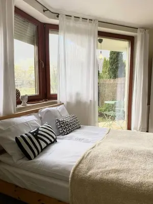a bed with pillows on it in front of a window at Green Garden Oasis in Kraków