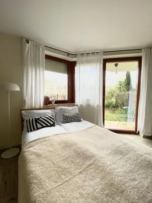 a bedroom with a large bed and a large window at Green Garden Oasis in Kraków