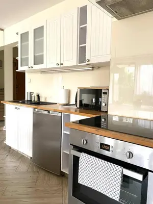 a kitchen with stainless steel appliances and white cabinets at Green Garden Oasis in Kraków