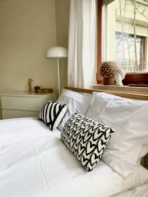 a white bed with two pillows and a window at Green Garden Oasis in Kraków
