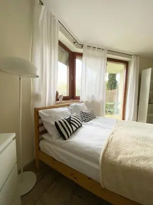a bedroom with a bed with pillows and a window at Green Garden Oasis in Kraków