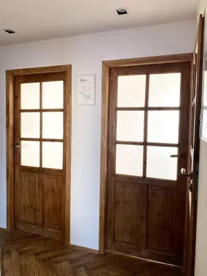two doors in a room with white walls and wooden floors at Comfortable and large apartment in Kraków