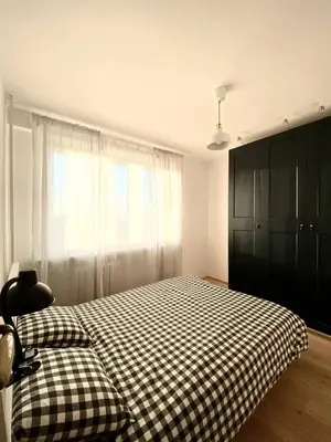 a bedroom with a checkered bed and a window at Comfortable and large apartment in Kraków