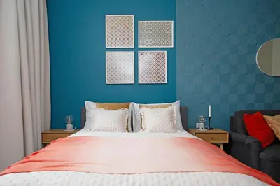a bedroom with a bed and a blue wall at LORETO 3 by Cozyplace in Kraków