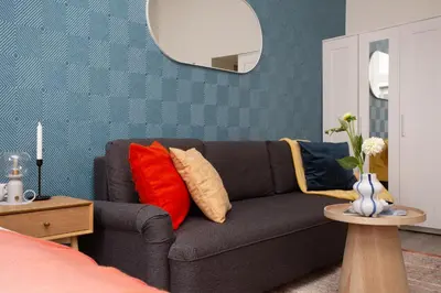 a living room with a gray couch with red pillows at LORETO 3 by Cozyplace in Kraków