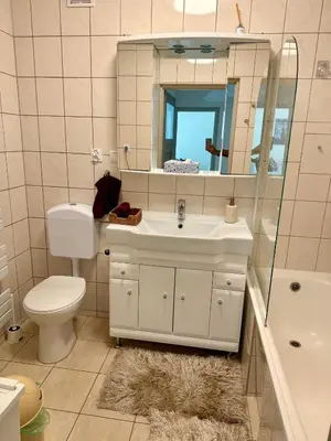 a bathroom with a sink and a toilet and a mirror at Kraków Nest in Kraków
