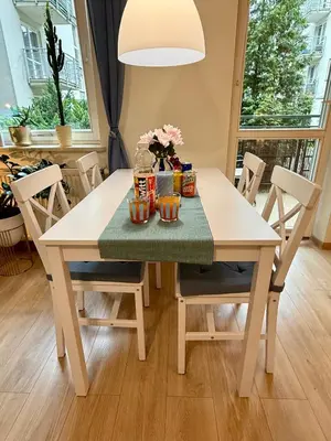 a white dining room table with flowers on it at Kraków Nest in Kraków