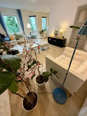 a living room with a white couch and plants at Kraków Nest in Kraków