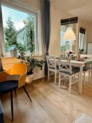 a dining room with a table and chairs and a window at Kraków Nest in Kraków