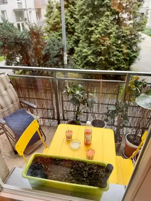 a yellow table with two glasses on a balcony at Kraków Nest in Kraków