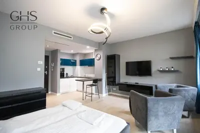 a bedroom with a bed and a living room at Ekskluzywny apartament w centrum, Balkon in Kraków