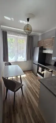 a living room with a table and a kitchen at W Rabczańskiej Dolinie in Rabka