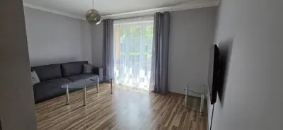 a living room with a couch and a large window at W Rabczańskiej Dolinie in Rabka