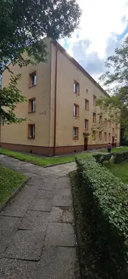 a large building with a sidewalk in front of it at W Rabczańskiej Dolinie in Rabka