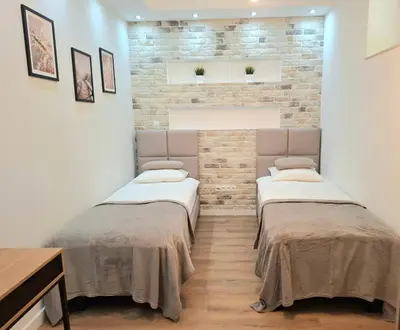 two beds in a room with a brick wall at sPokoje in Wieliczka