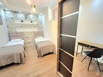 a room with two beds and a desk in it at sPokoje in Wieliczka