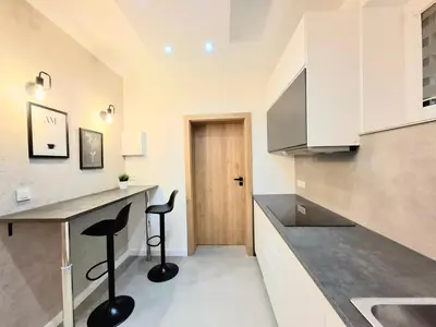 a kitchen with a desk and two stools in it at sPokoje in Wieliczka